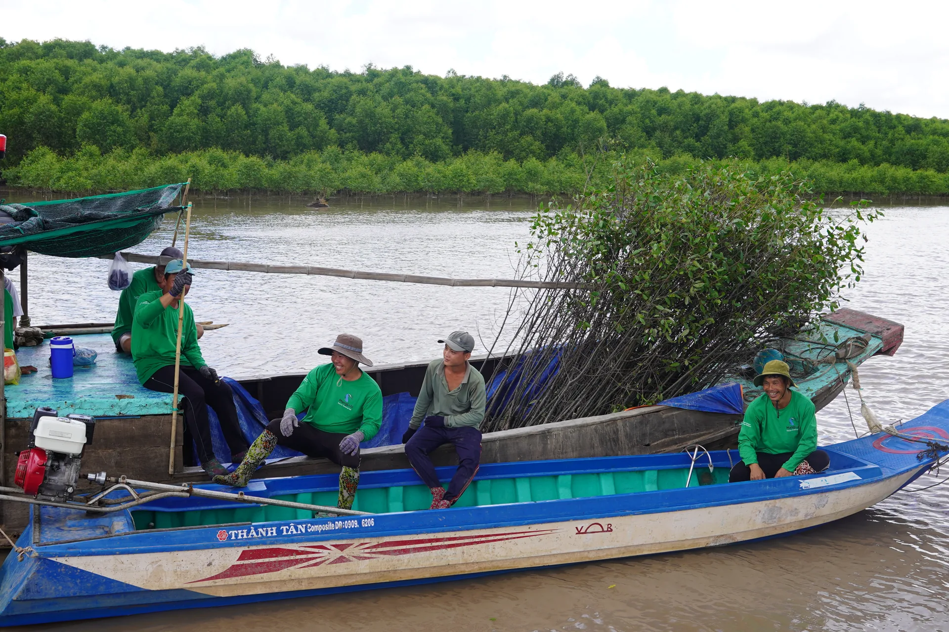 Nhóm trồng rừng địa phương vận chuyển cây giống trên thuyền